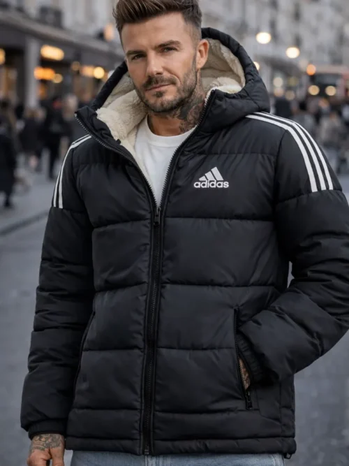 A premium Adidas black puffer jacket for men with white stripes, featuring a warm sherpa-lined hood and quilted insulation for winter weather.