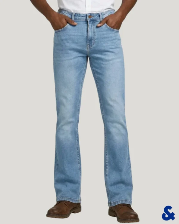 Men wearing light sky blue wash bootcut denim pant with hands in pockets, styled with brown boots.