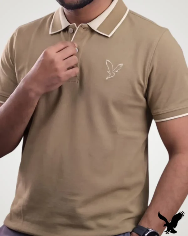 Men's light khaki beige polo shirt featuring cream tipped collar trim and a white outline eagle logo by Signature Lifestyle