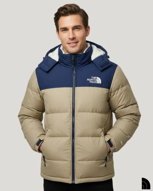 Man wearing a navy blue and tan color-blocked puffer jacket with a high stand-up collar.