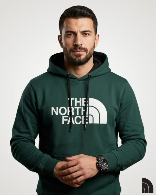 Front view of a model wearing a deep green classic mens hoodie, designed with a prominent white chest logo print, contrast black hood lining, matching drawstrings, and a front pouch pocket.