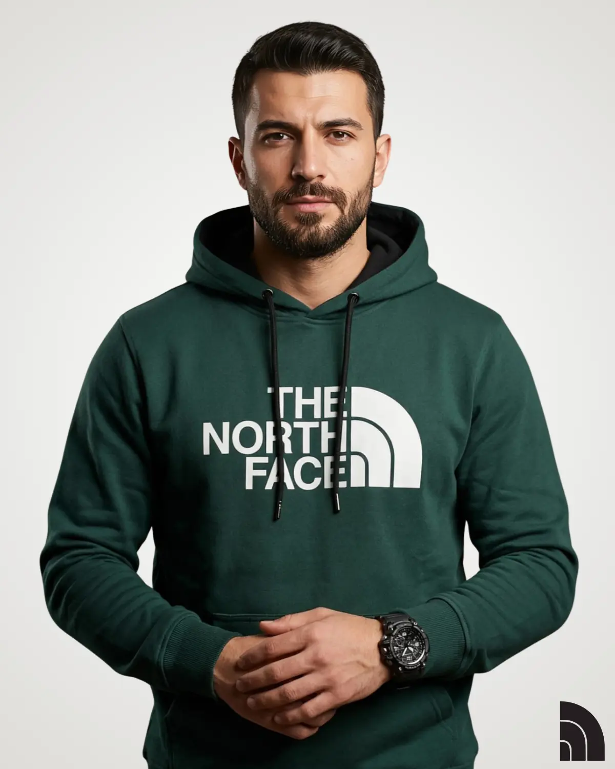 Front view of a model wearing a deep green classic mens hoodie, designed with a prominent white chest logo print, contrast black hood lining, matching drawstrings, and a front pouch pocket.