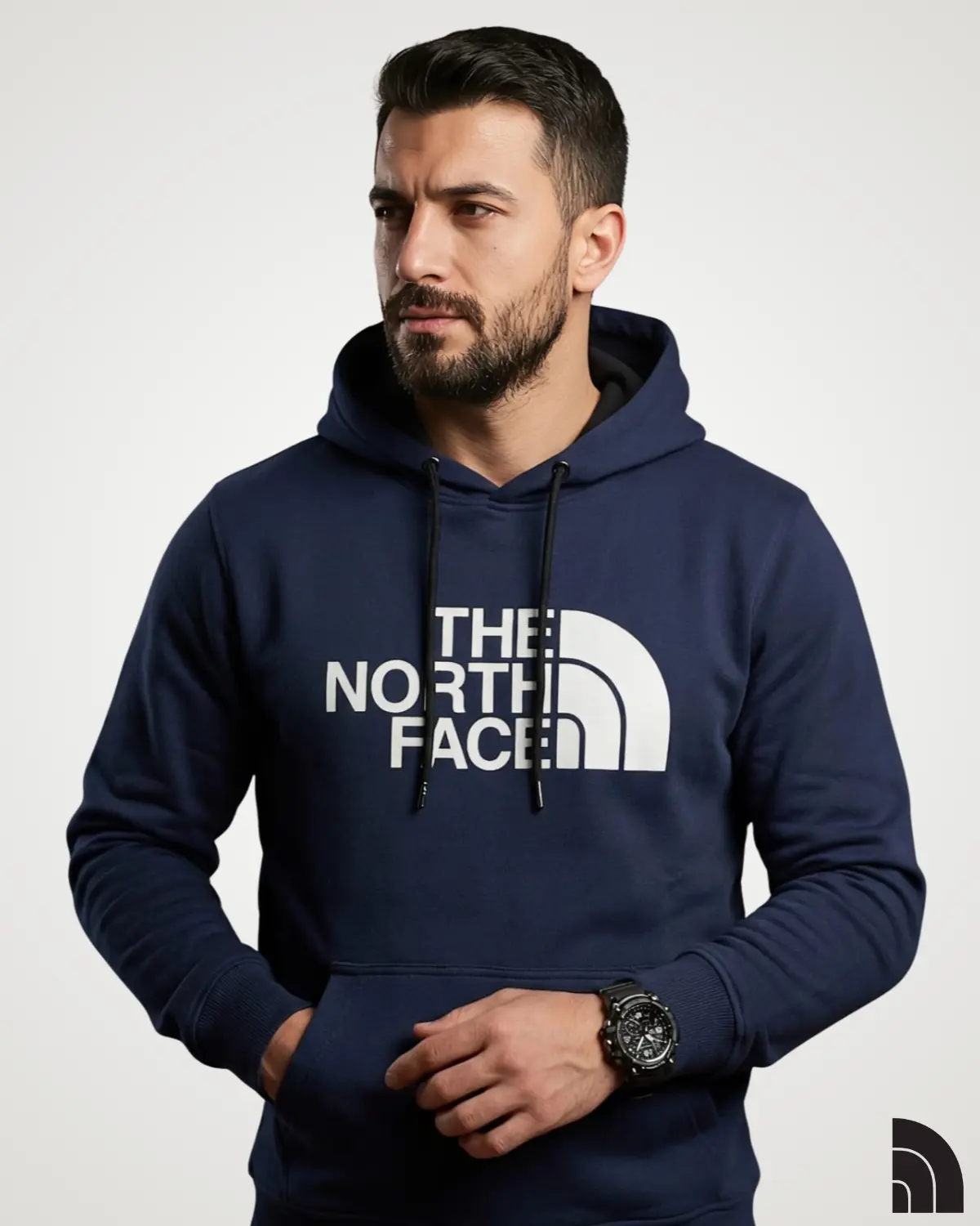 A male model dressed in a dark navy blue classic mens hoodie, showcasing a central white text graphic print, black adjustable drawstrings, and ribbed cuffs for a snug fit.