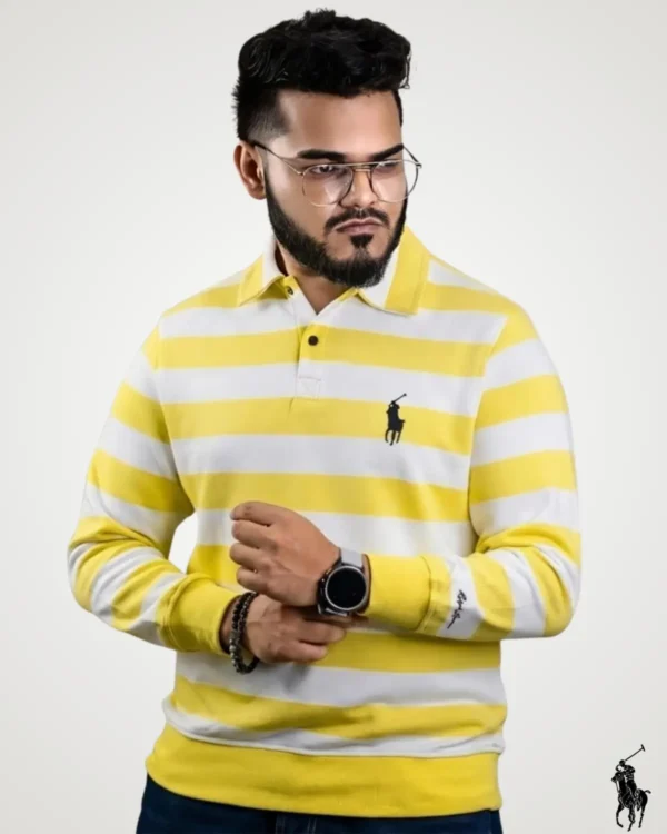 Model posing in a bright yellow and white full sleeve striped polo shirt, styled with a traditional polo collar, ribbed cuffs, and a small black embroidered logo on the left chest.