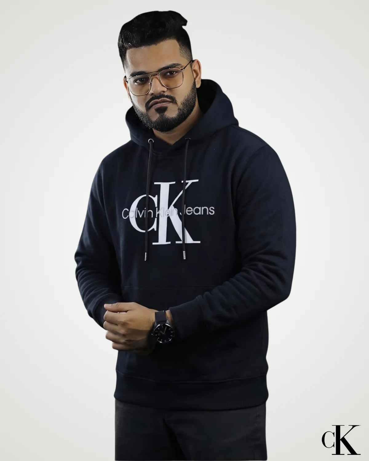 A stylish model wearing a classic black Export Quality Pullover Hoodie featuring a bold white minimal logo print on the front chest, drawstring adjustable hood, ribbed cuffs, and a front pouch pocket.