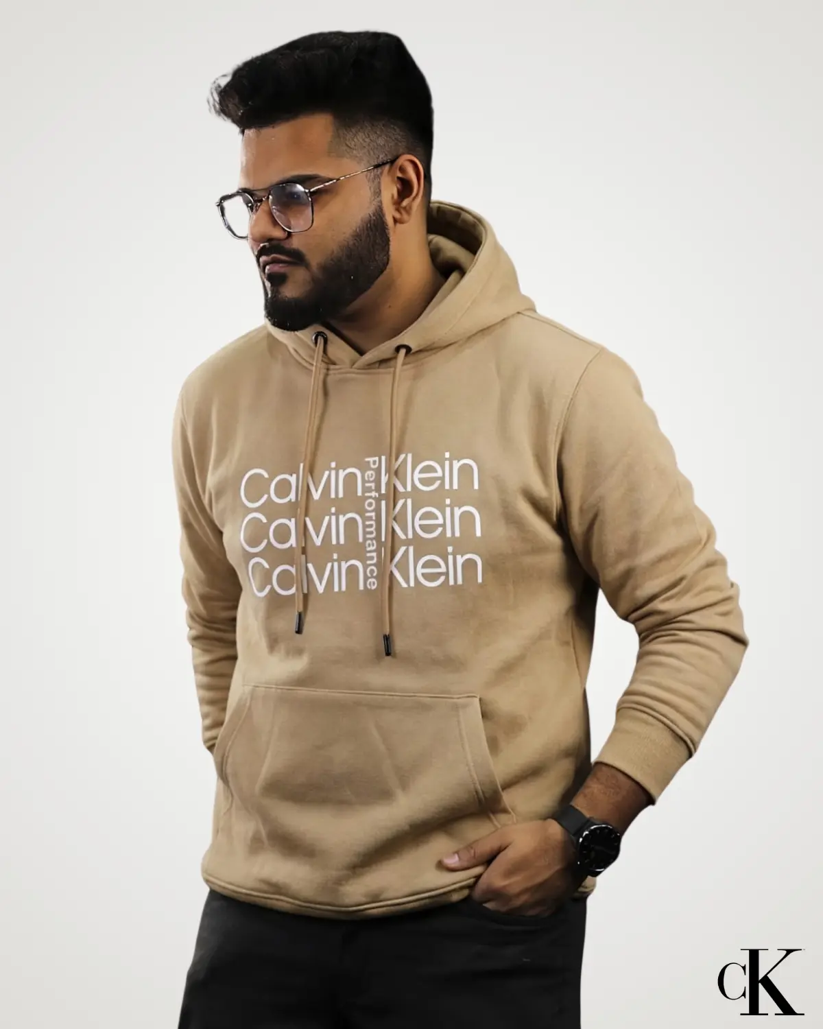 Model wearing a light beige mustard brown Export Quality Pullover Hoodie, styled with stacked white text graphic print across the center chest, long sleeves with fitted cuffs, and matching drawstrings.