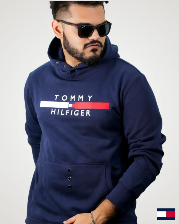 Front-side view of a man posing in a dark navy blue snap button hoodie men style, styled with button snap neck closures, printed chest design with red and white accents, and a spacious front pouch.